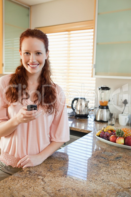 Woman in the kitchen with her cellphone