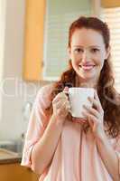 Smiling woman with cup in her hands