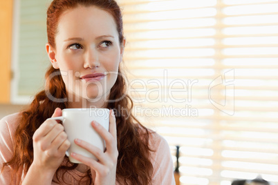 Woman with a cup in thoughts