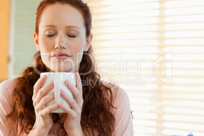Woman enjoys the smell of her coffee