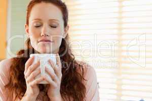 Woman enjoys the smell of her coffee