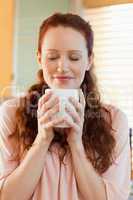 Joyful woman holding a cup of coffee