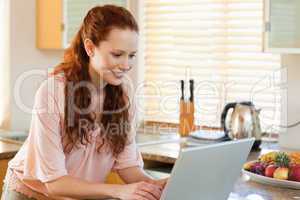 Woman with her laptop in the kitchen