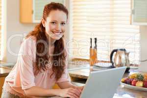 Woman using her laptop in the kitchen