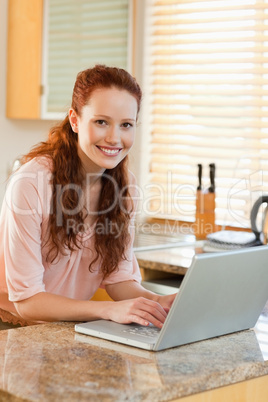 Woman with her laptop next to the kitchen counter