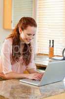 Woman using her notebook in the kitchen
