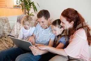 Family using notebook on the sofa