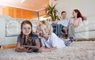 Brother and daughter using tablet on the carpet