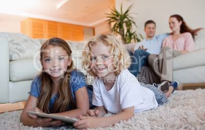 Siblings on the carpet using tablet