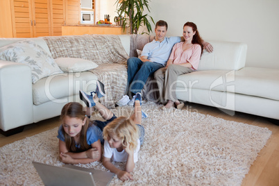 Brother and sister with laptop on the carpet