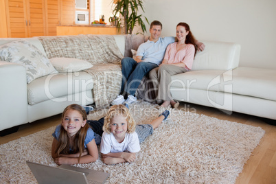 Siblings with laptop on the floor