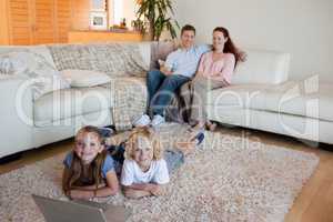 Siblings with laptop on the floor