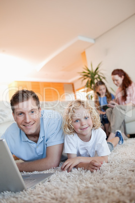 Father and son using internet on the floor