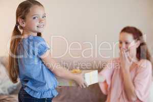 Girl giving her mother a present