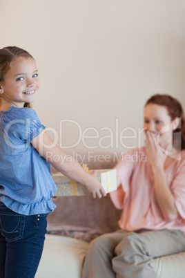 Little girl giving her mother a present