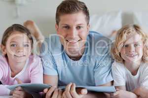Smiling father with his children and a magazine