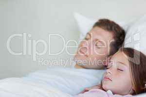 Side view of father and daughter asleep