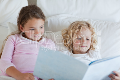 Brother and sister reading bed time story