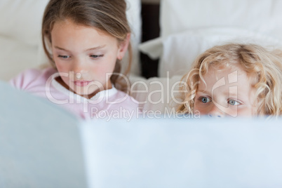 Girl reading a bed time story for her brother