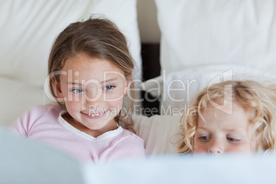 Girl reading a fairy tale for her brother