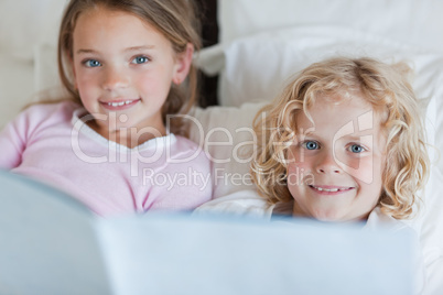 Siblings enjoy reading bed time story