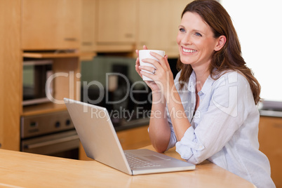 Woman with cup and notebook in the kitchen
