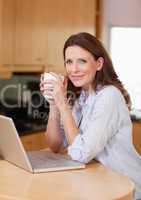Woman with laptop and a cup