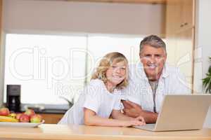 Smiling father and son with laptop