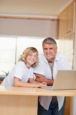 Father and son with laptop in the kitchen