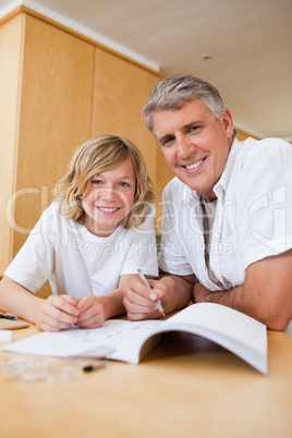 Boy getting help with homework from father