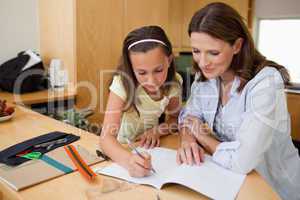 Girl doing homework with her mother