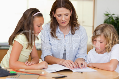 Woman helping children with homework