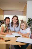 Siblings getting help with homework from mother