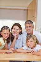 Smiling family behind kitchen table