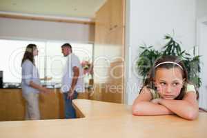 Sad girl listening to fighting parents