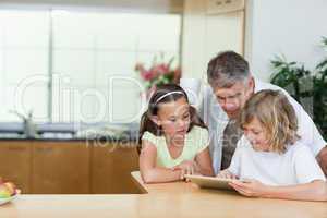 Man looking at tablet his children are using