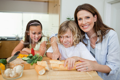 Mother making sandwiches with her children