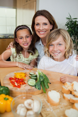 Smiling mother making sandwiches with her children