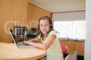 Girl with laptop at the kitchen table