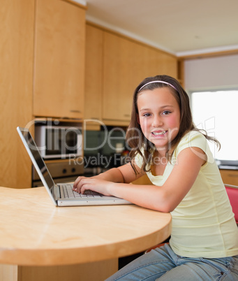 Girl with her laptop at the kitchen table