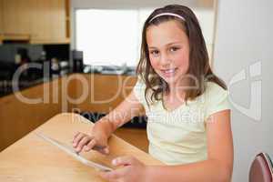 Girl with tablet at the kitchen table
