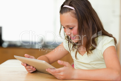 Girl at kitchen table looking at tablet