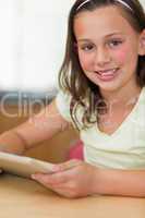 Girl sitting at table with tablet