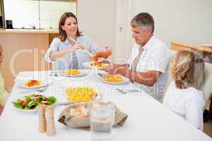 Woman serving dinner to family