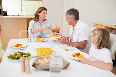 Woman serving dinner to hungry family