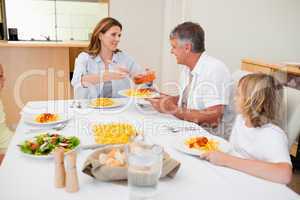 Woman serving dinner to hungry family