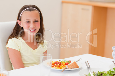 Smiling girl with dinner at the table