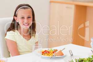 Smiling girl with dinner at the table
