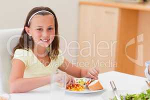 Smiling girl having dinner at dinner table