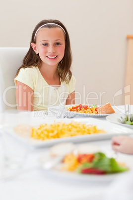 Smiling girl sitting at dinner table